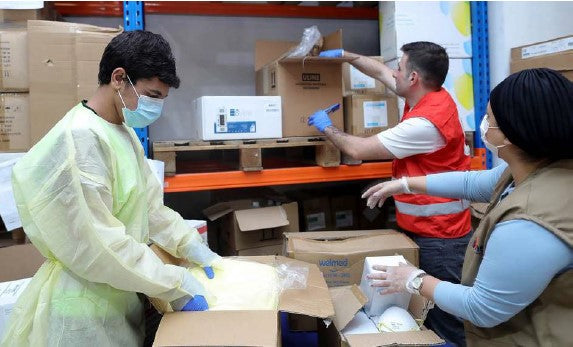 ANERA staff distributing protective equipment, provided by Welmed and other donors.